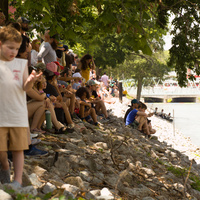 A crowd lines the rocky bank awaiting the release of the ducks.